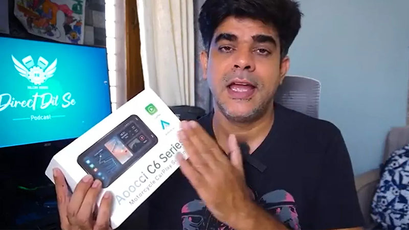 Person holding a smartphone box with a screen in the background