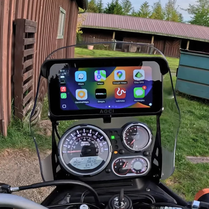 Motorcycle dashboard with a digital display showing app icons in an outdoor setting.